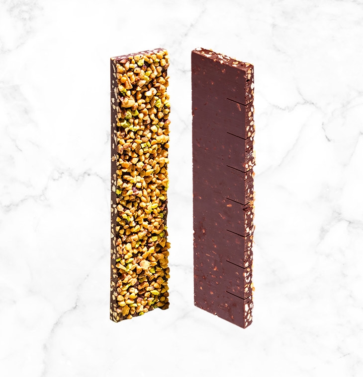 A crunchy mixture of almonds, pistachios and hazelnuts on a thin layer of dark chocolate, creating the perfect bar to share, presented in an elegant and brightly colored box.