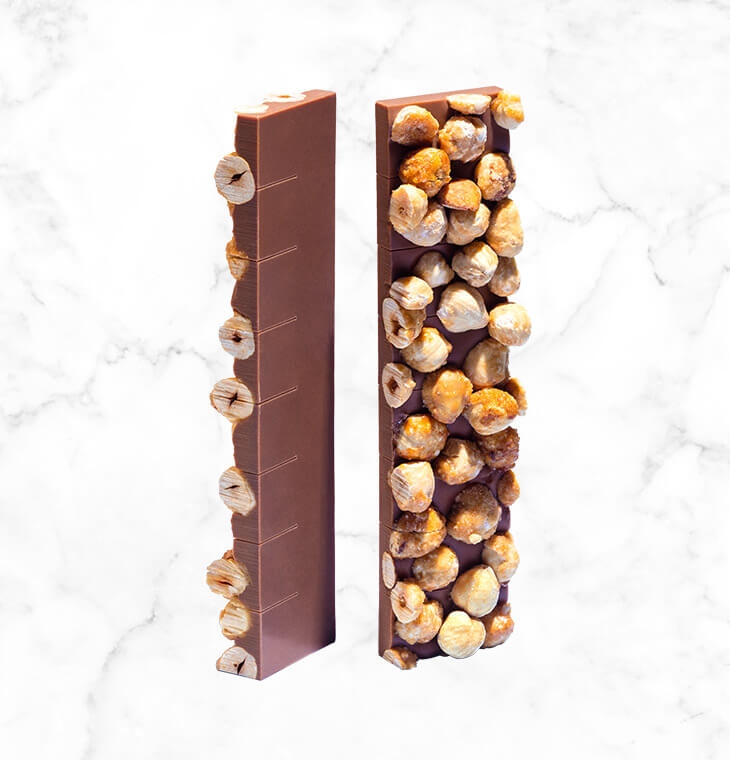 A milk chocolate bar with a twist, featuring a generous layer of whole and caramelized hazelnuts, an incredibly crunchy texture and couture expertise in a shocking pink box.