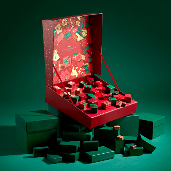 Chocolats fins et savoureux cachés derrière chaque fenêtre du Calendrier de l'Avent écrin cadeau rouge de la Maison du Chocolat